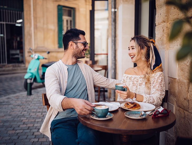 Paar sitzt in einem Kaffee und lacht miteinander
