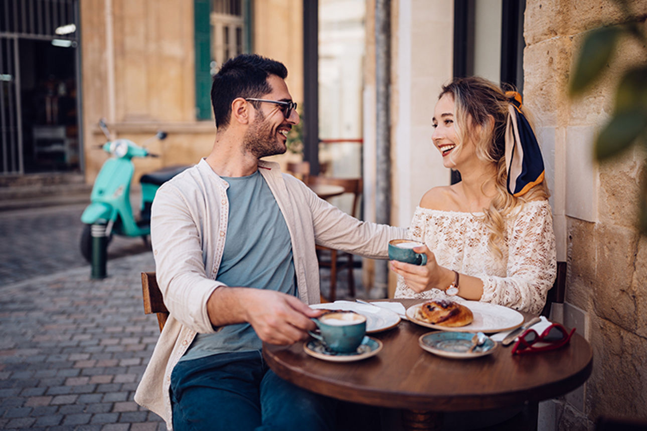 Paar sitzt in einem Kaffee und lacht miteinander