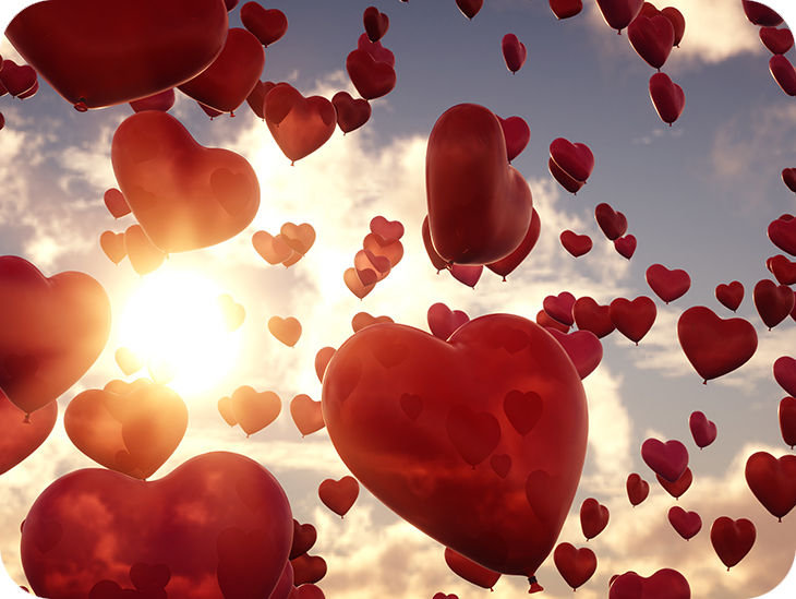 Viele rote Herzluftballons im Himmel