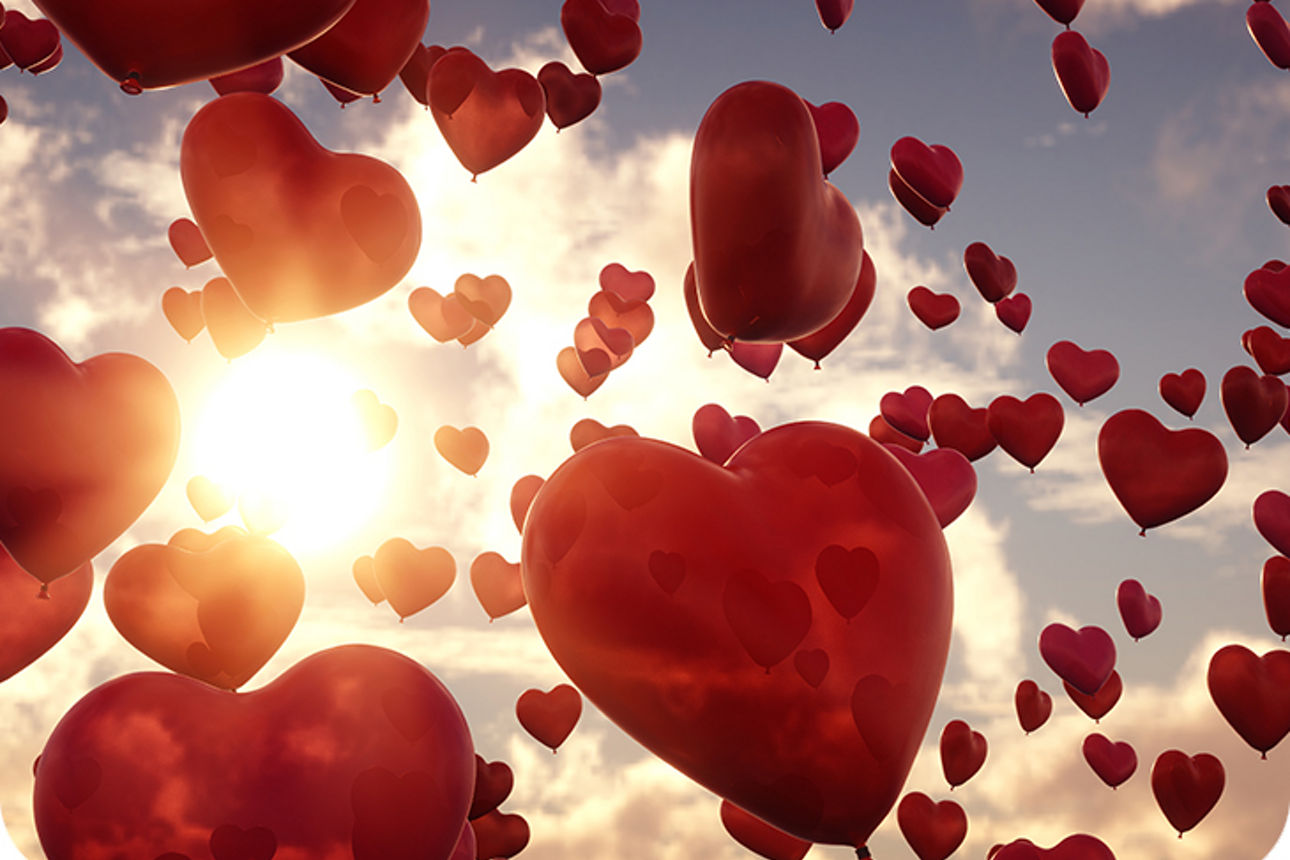 Viele rote Herzluftballons im Himmel