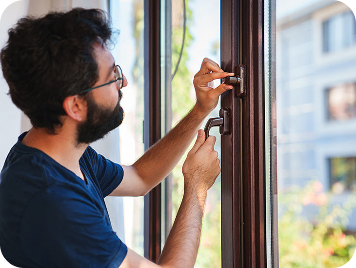 Mann macht ein Fenster Einbruchsicher
