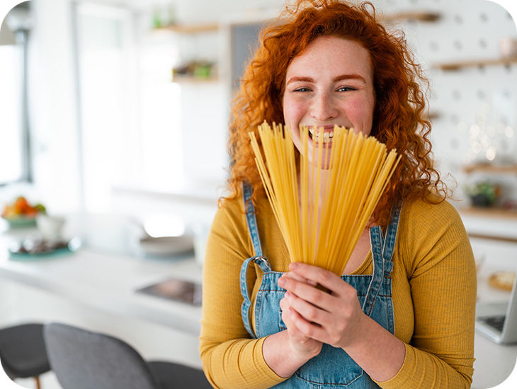 Frau hält Spaghettis in der Hand