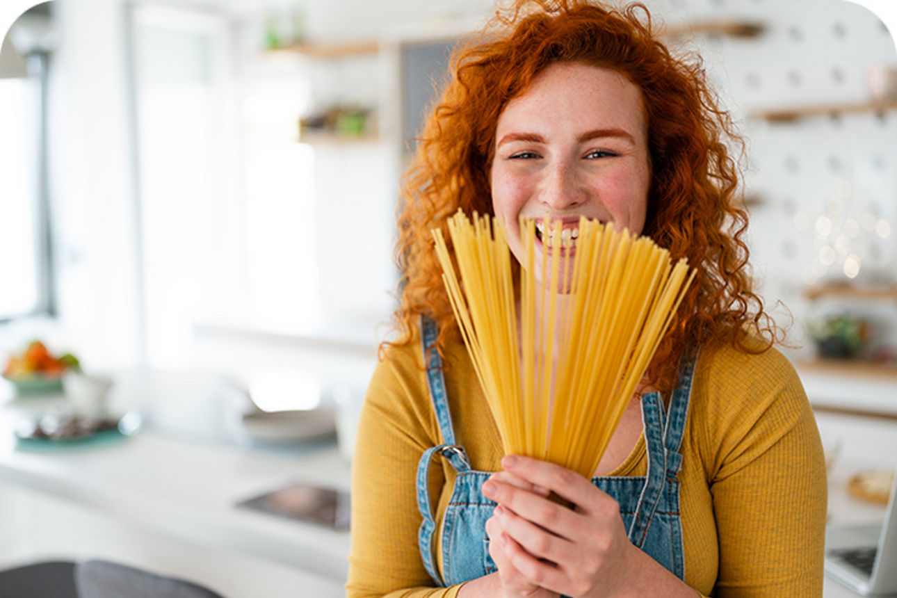 Frau hält Spaghettis in der Hand