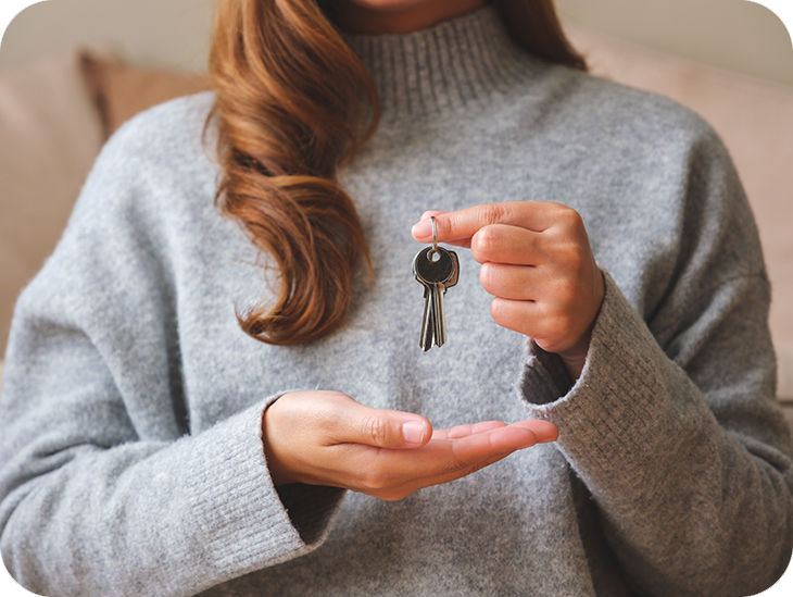 Frau hält einen Schlüssel in der Hand