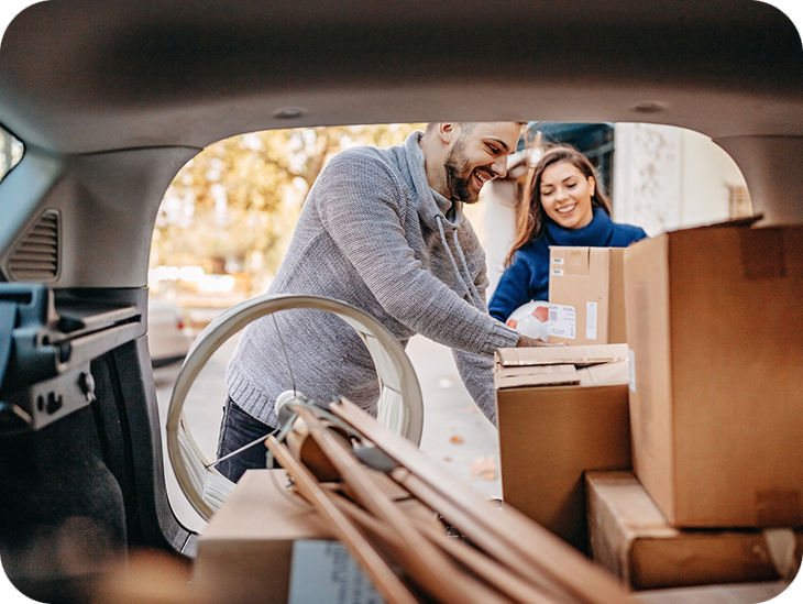 Paar packt eine Auto mit Umzugskartons