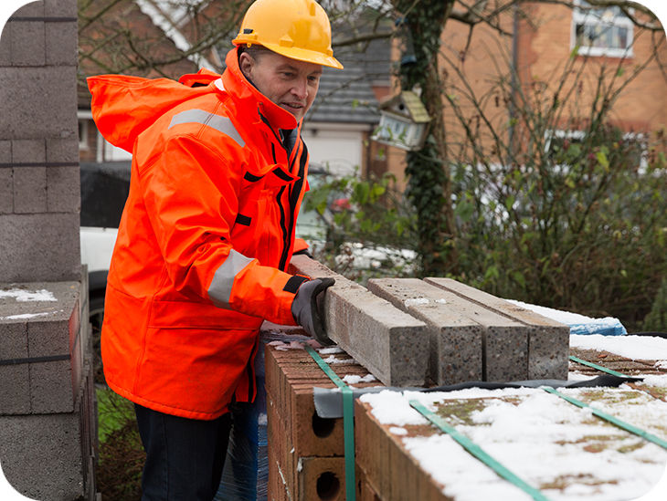 Mann in Warnjacke auf einer Baustelle