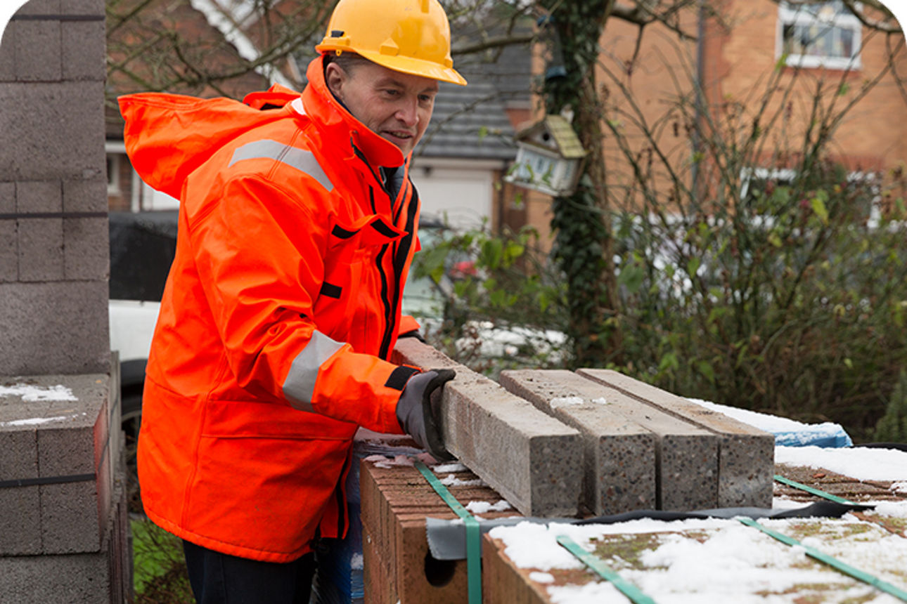 Mann in Warnjacke auf einer Baustelle