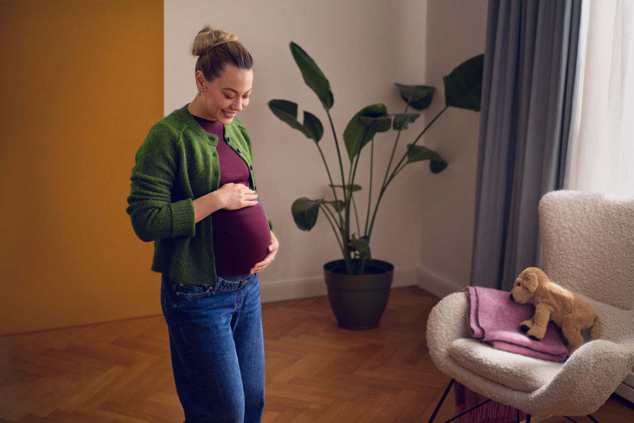 Schwangere Frau streicht über ihren Bauch