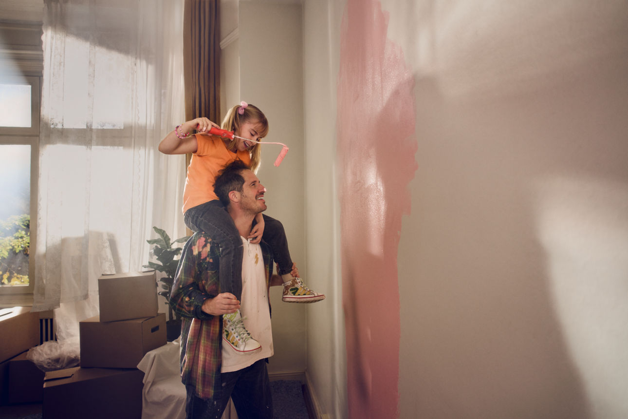 Mann mit Kind auf der Schulter streichen Wand 