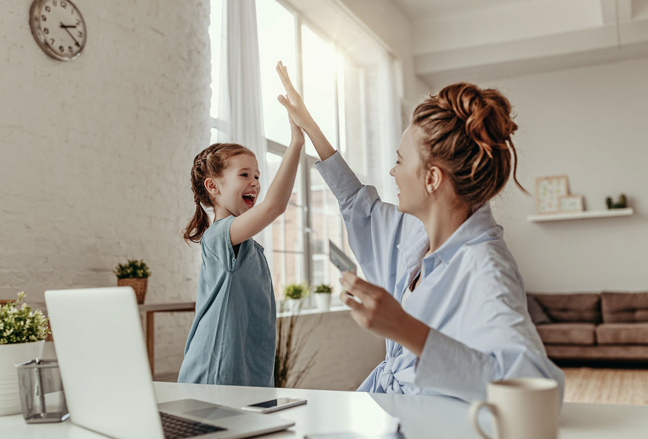 Die Mutter und ihre Tochter klatschen sich in die Hände und sind glücklich.