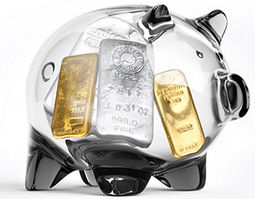 Ein durchsichtiges Glas-Sparschwein mit Silber- und Goldbarren