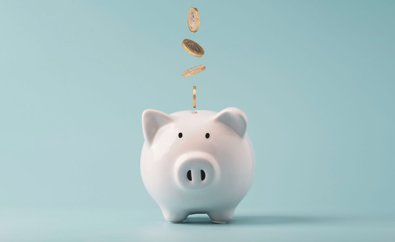 Coins falling to white piggy saving ,  Financial and money deposit concept.