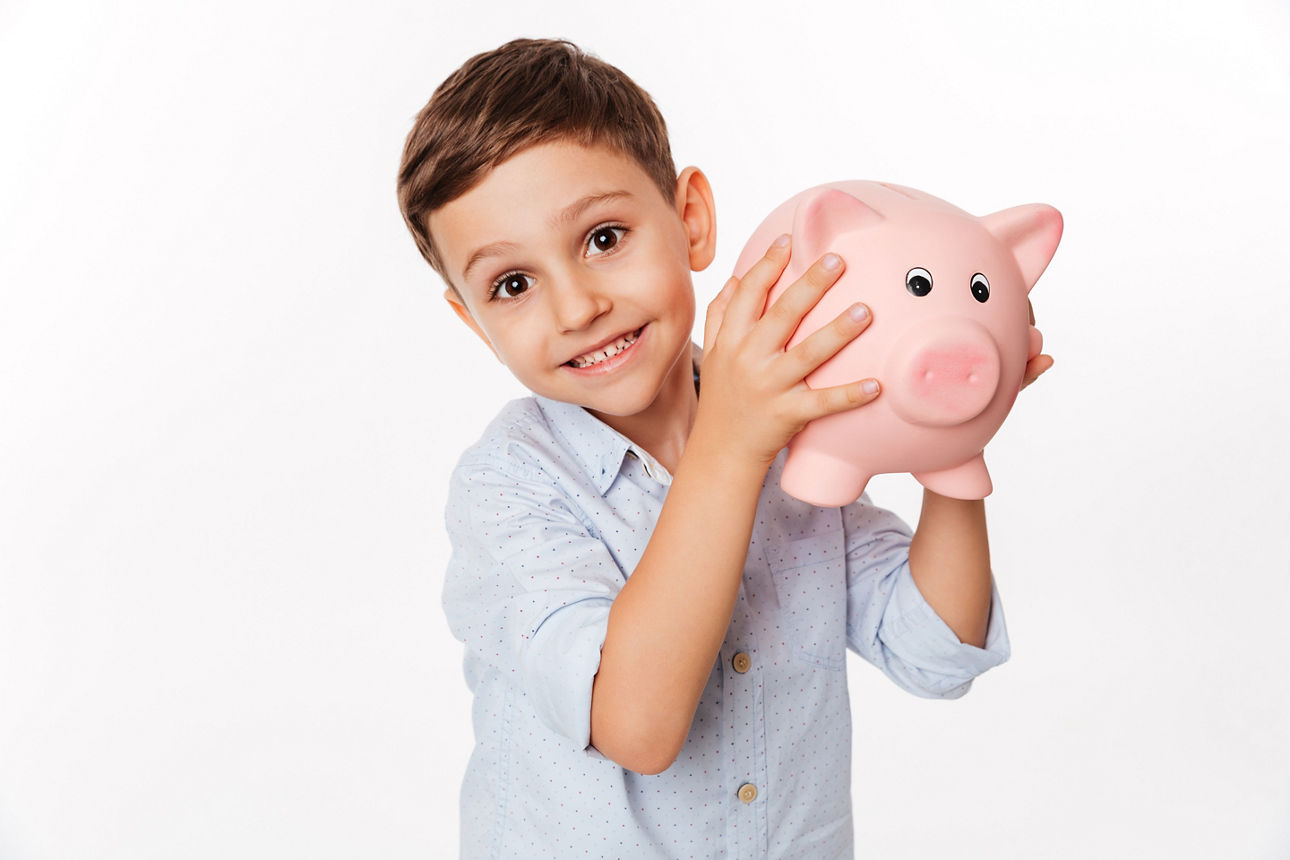 Kleiner Junge mit Sparschwein in derHand