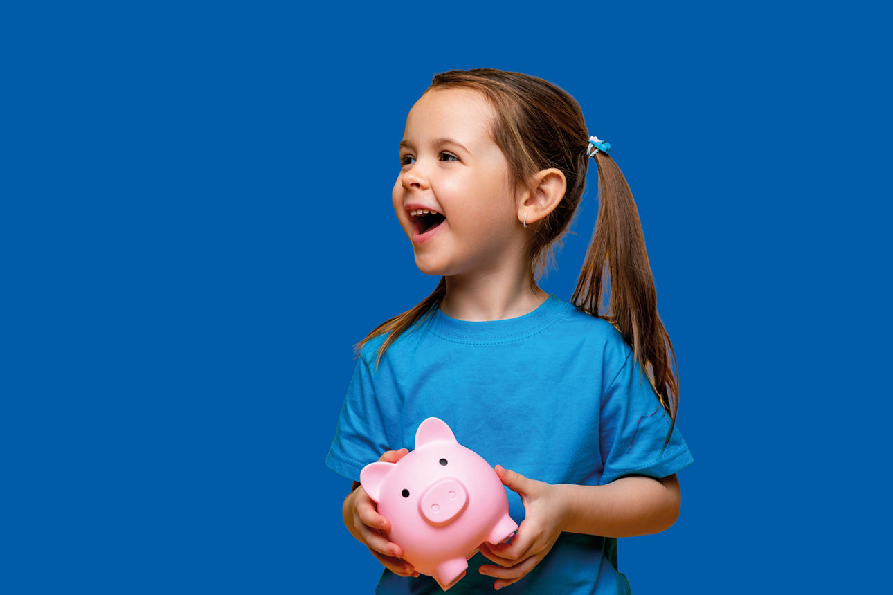 Junges Mädchen mit rosa Sparschwein in der Hand