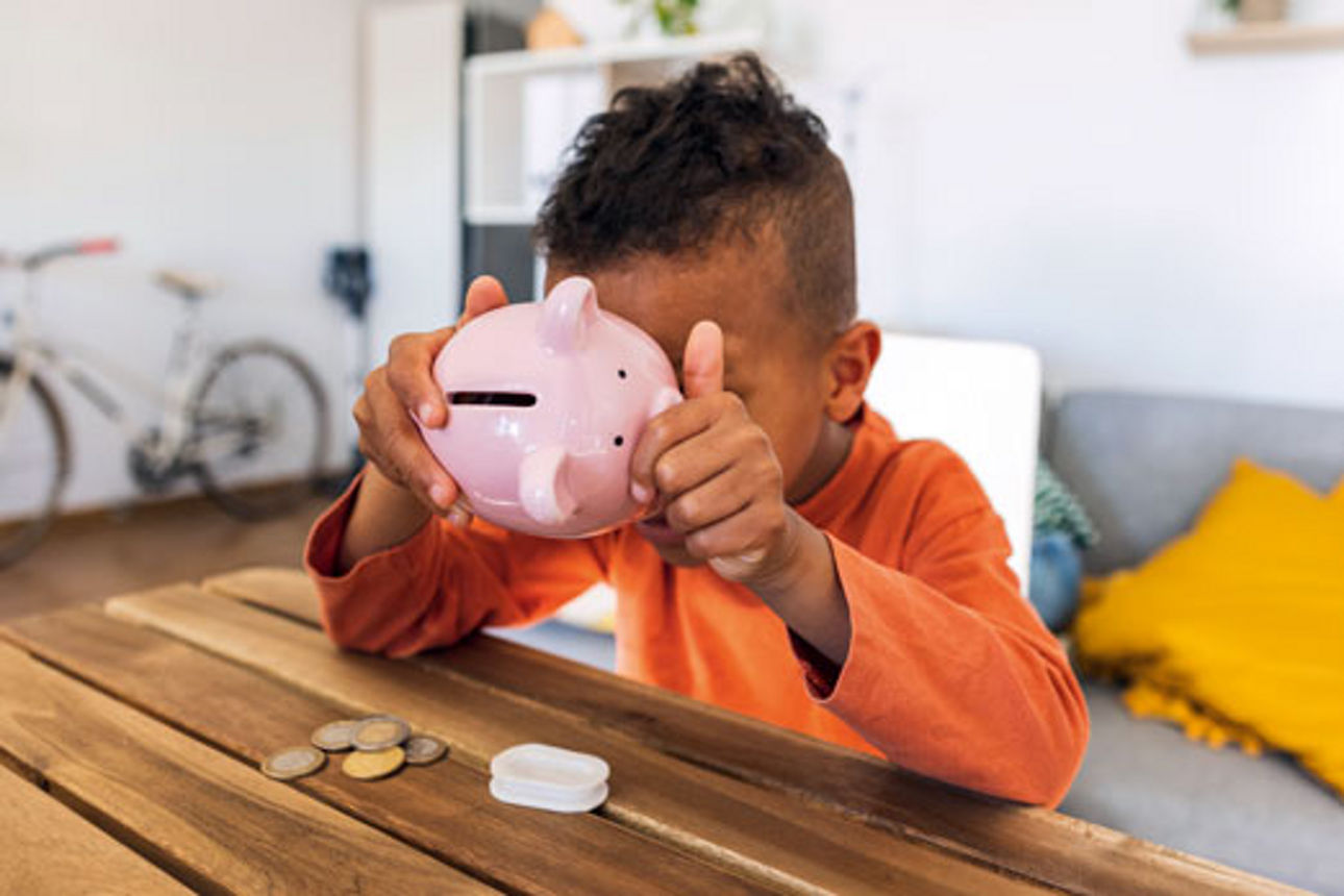 Kleiner Junge mit pinkem Sparschwein