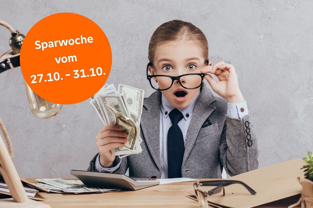 Junges Mädchen sitzt am Schreibtisch mit Geld in der Hand und ist überrascht, dass sie so viel gespart hat