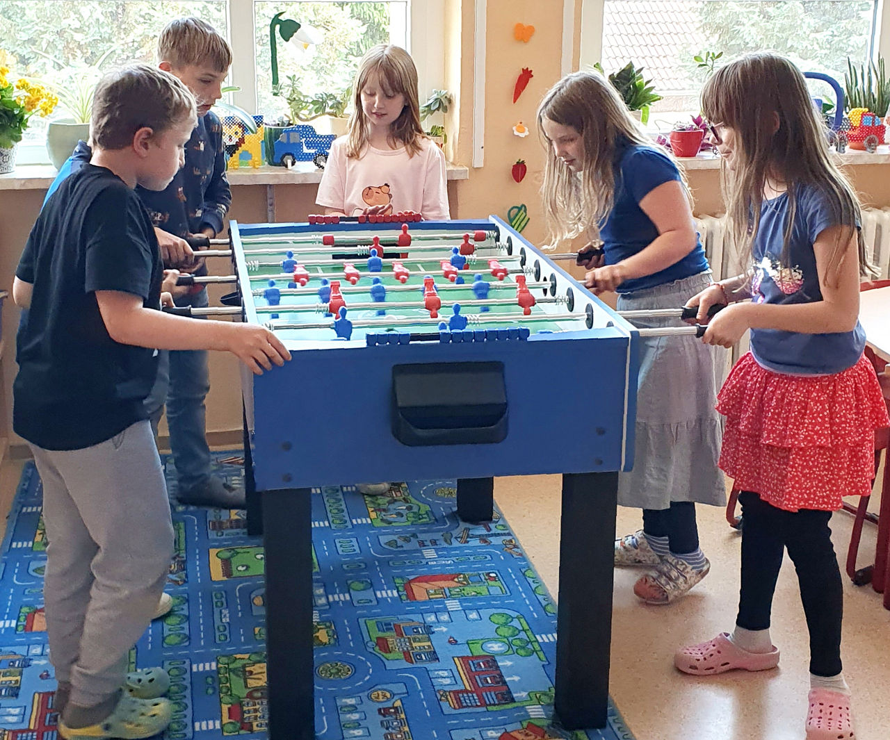 Kinder spielen am Tischkicker im Hort