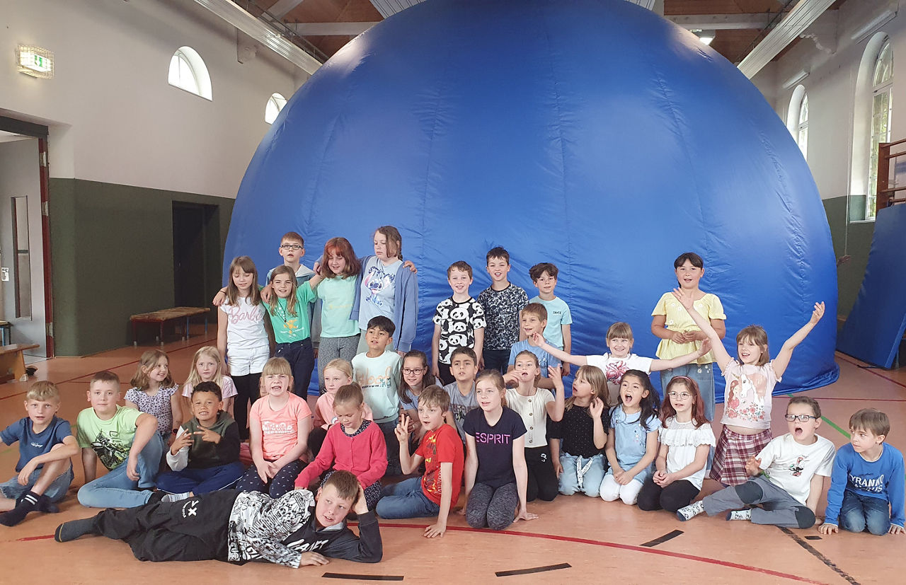 Kinder vor dem mobilen Planetarium in der Turnhalle