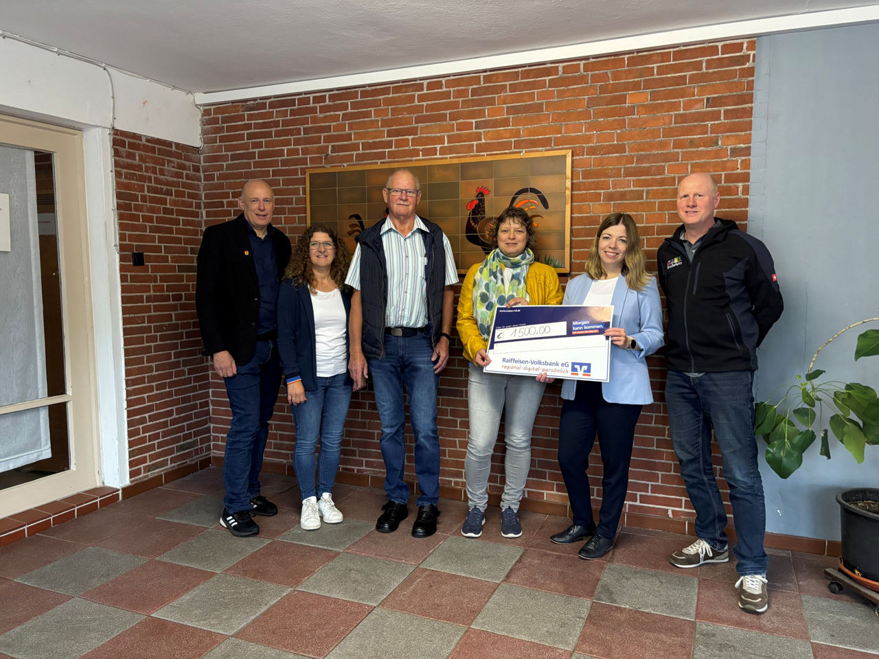 Sechs Personen mit Spendenscheck