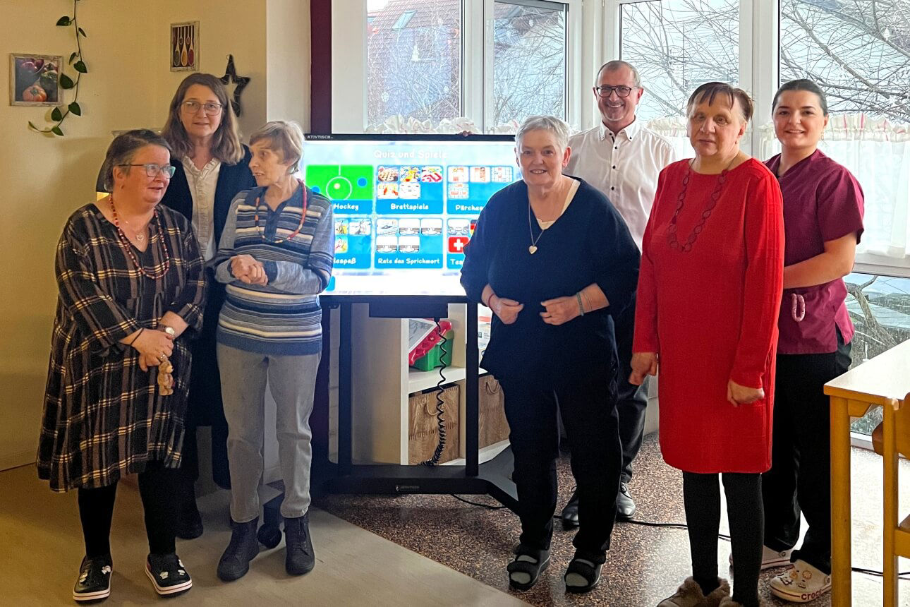 Spendenübergabe bei der Lebenshilfe mit Bewohnern, neuem Aktivtisch und Privatkundenberater unserer Bank
