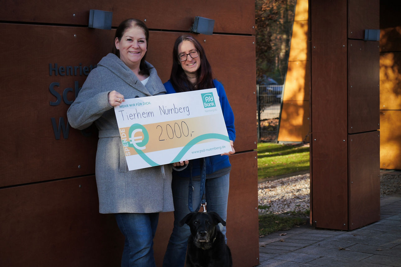 Ein Kollege der PSD Bank Nürnberg übergibt einen Spendencheck an das Tierheim Nürnberg