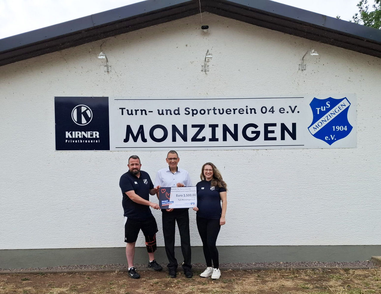 Drei Personen stehen für dem Vereinsheim des TuS Monzingen