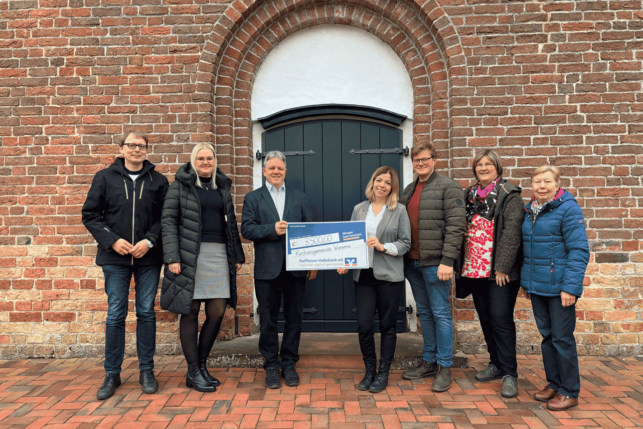 Sieben Personen bei der symbolischen Scheckübergabe