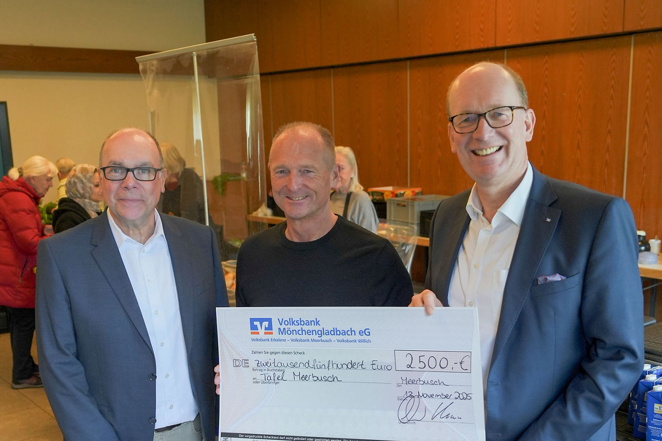 In einem Innenraum mit hellen Deckenlampen und beigefarbenem Fliesenboden stehen drei erwachsene Männer eng nebeneinander.