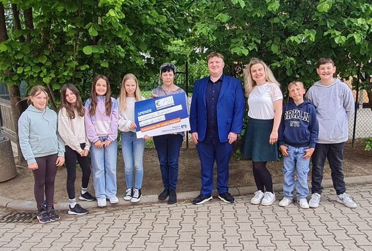 Übergabe des Präsentationsschecks an eine Kindergruppe