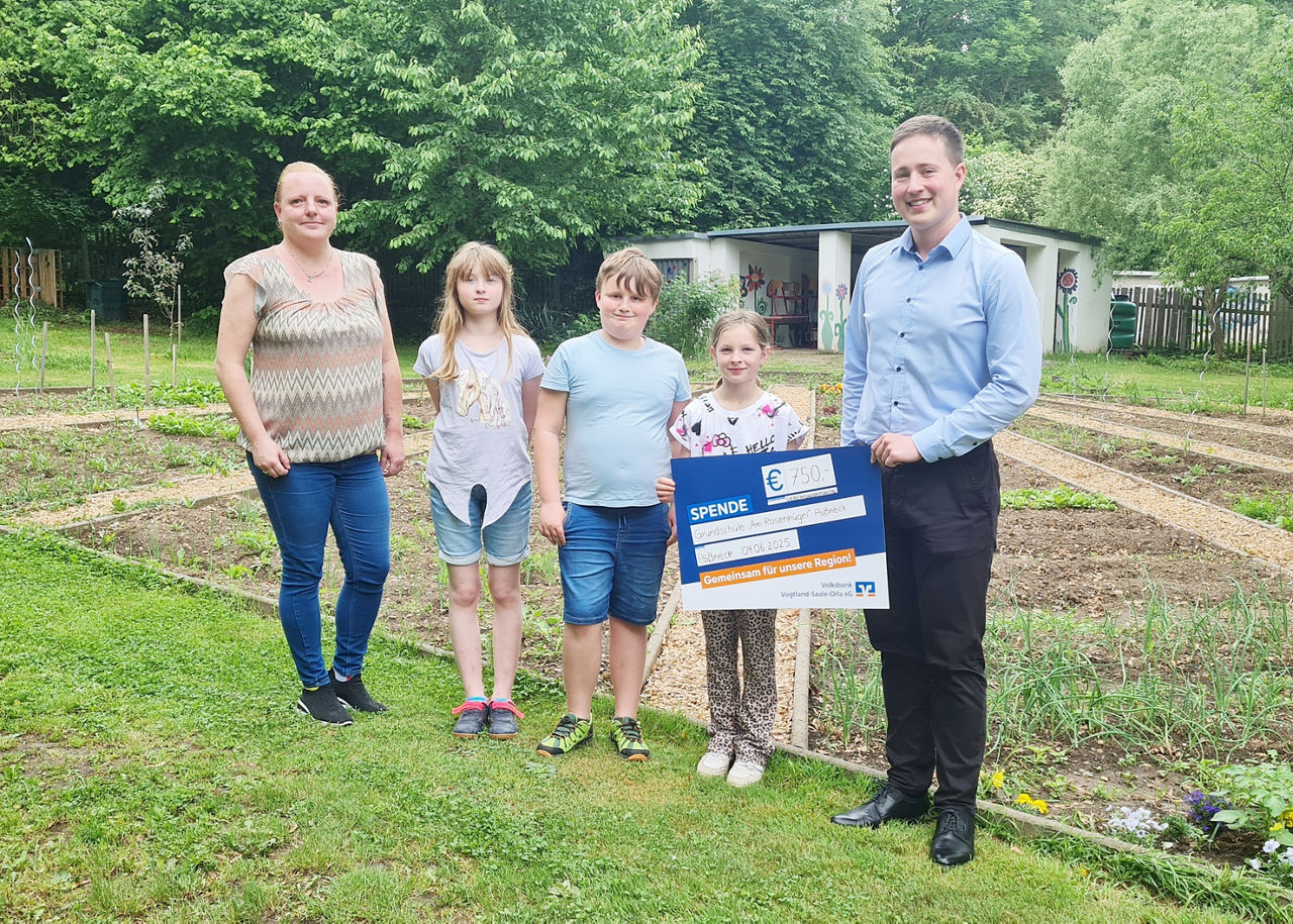 Übergabe des Präsentationsschecks im Schulgarten der Grundschule