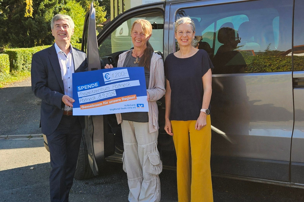 Übergabe des Präsentationsschecks vor dem neuen Fahrzeug des Freizeitzentrums