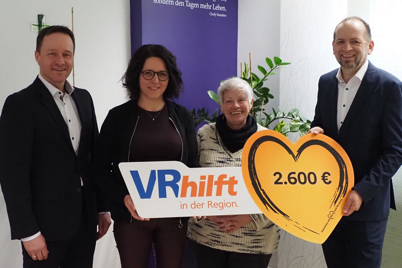 Zwei Kollegen halten zusammen mit zwei Vertreterinnen eines begünstigten Vereins den Spendenscheck in der Hand