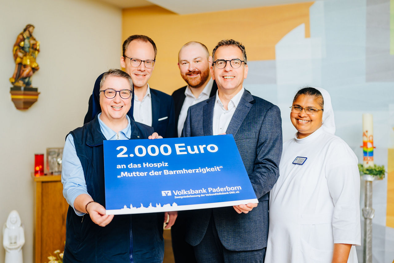 Mitarbeiter der VerbundVolksbank OWL eG übergeben einen Spendenscheck an Mitarbeiter des Hospizes. 