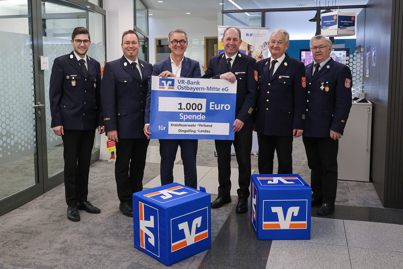 Sechs Männer, fünf davon in Feuerwehruniform halten eine Spendentafel über 1000 Euro hoch