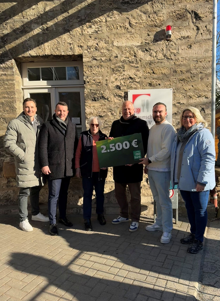 Mehrere Menschen aus der Tafel und der Bank halten einen Scheck in der Hand