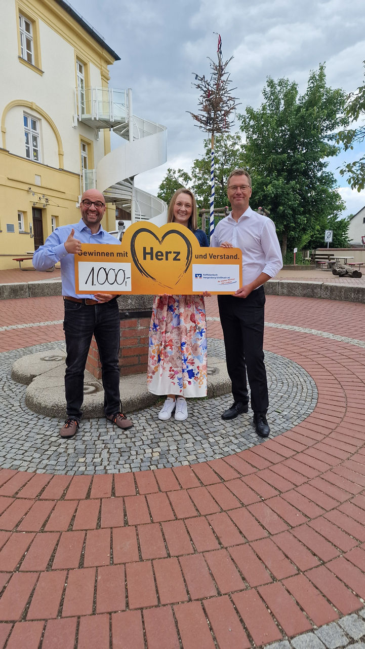 Schulleitung mit Vertretern der Bank auf dem Schulgelände