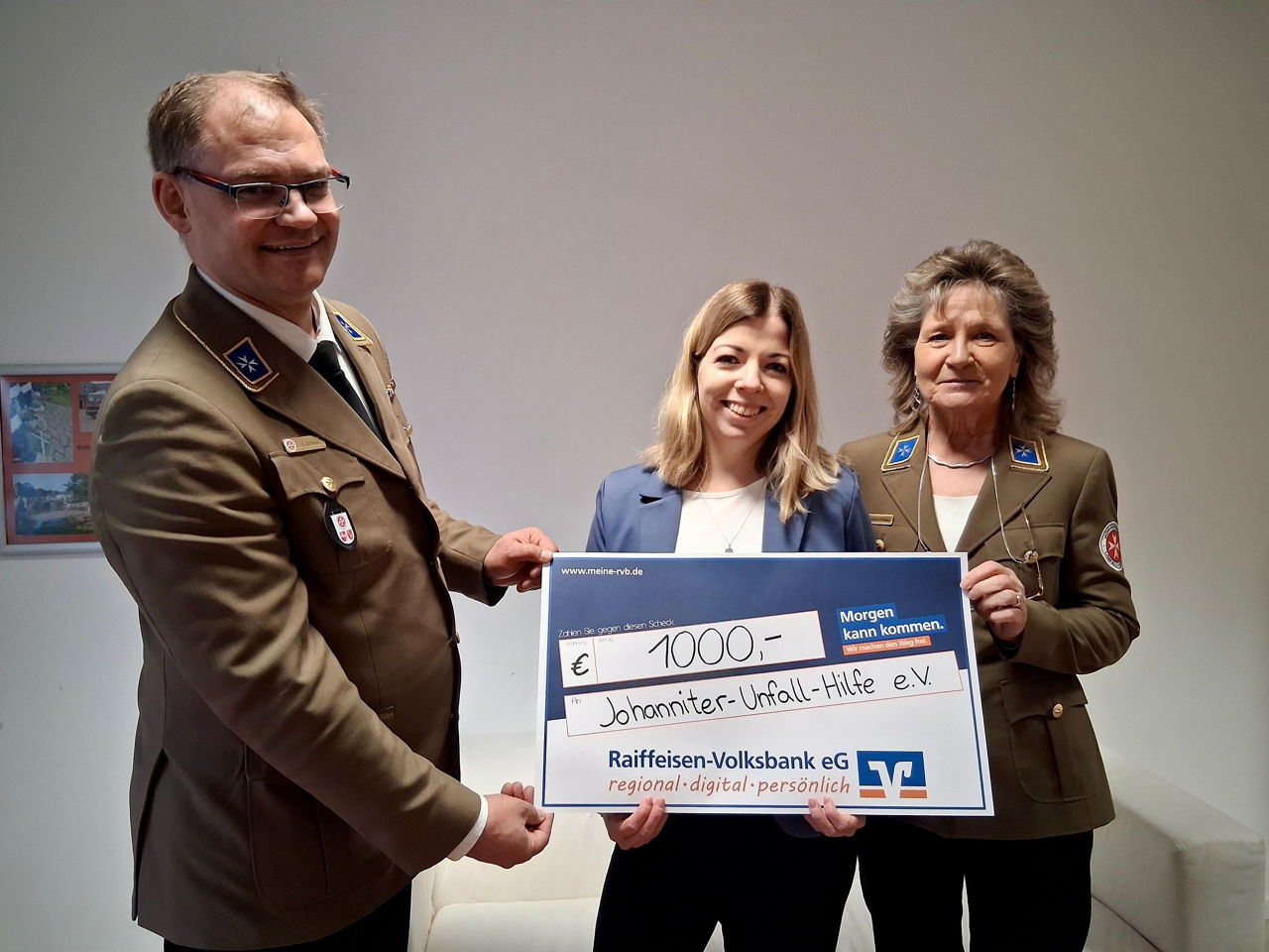 Drei Personen mit symbolischen Scheck