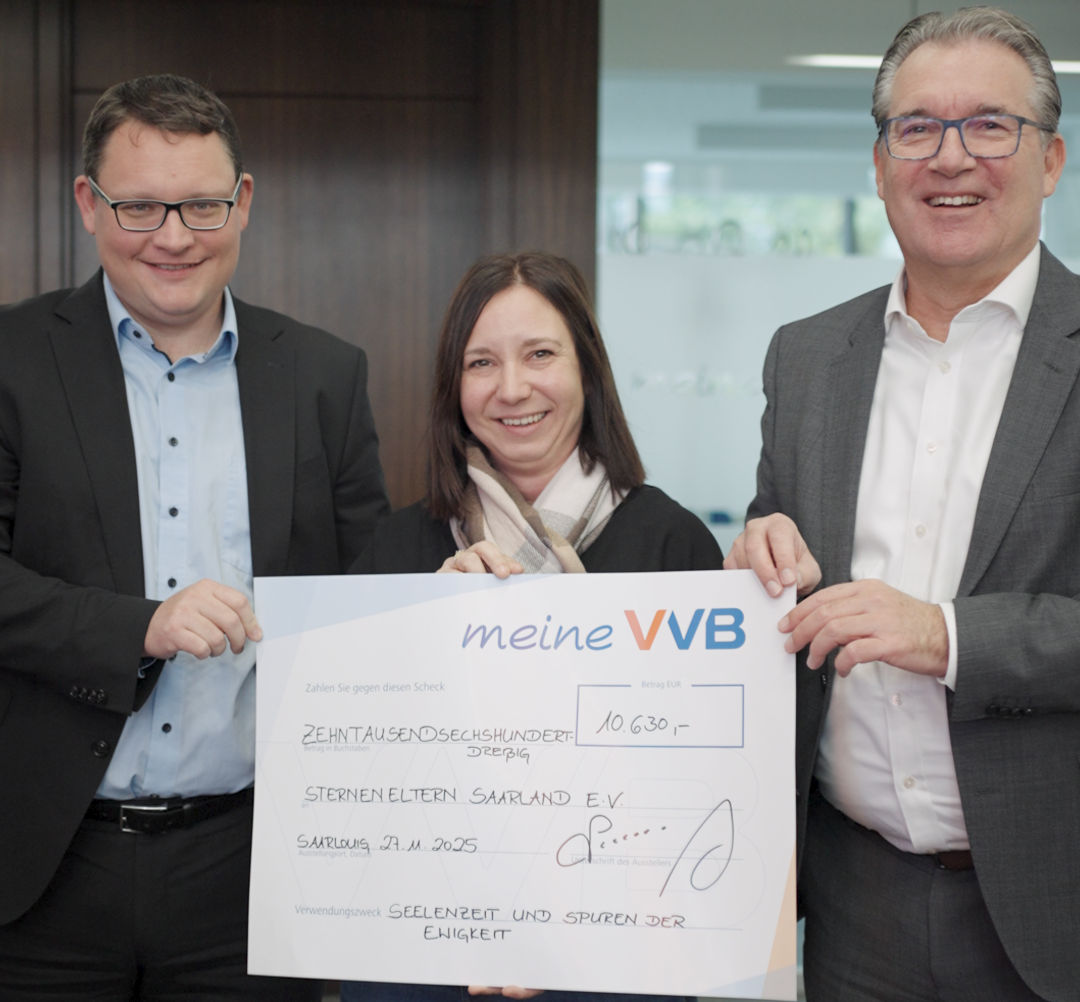 zwei Herren des Vorstandes und eine Frau bei der Scheckübergabe