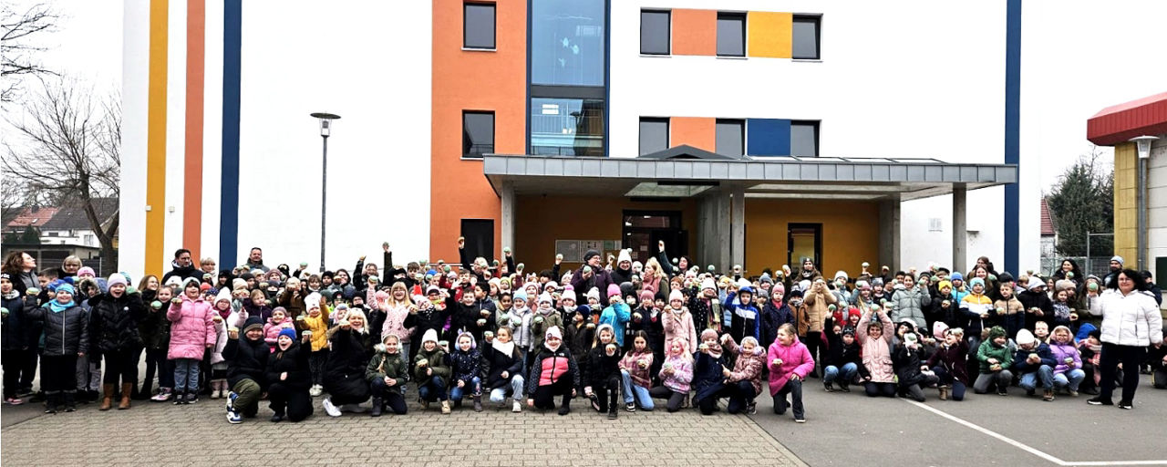 Foto einer Klasse zum "Funkuchen-Tag" vor einer Schule