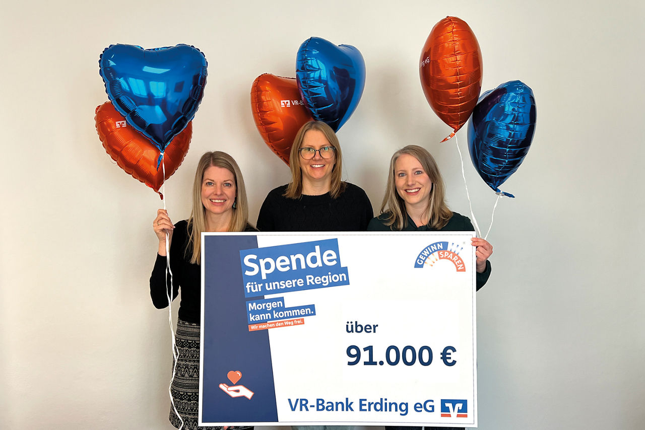 Mitarbeiterinnen der VR-Bank Erding eG präsentieren 91.000 Euro Spendenscheck mit Luftballons