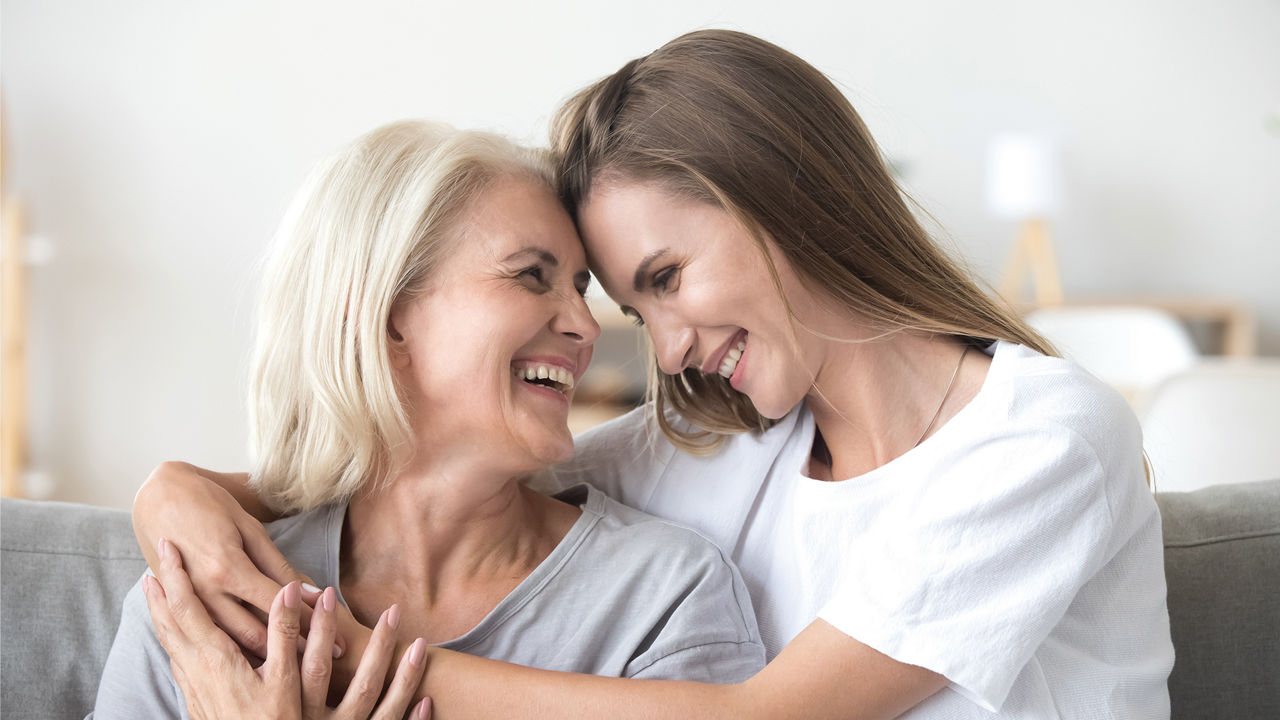 Eine junge Frau umarmt ihre Mutter