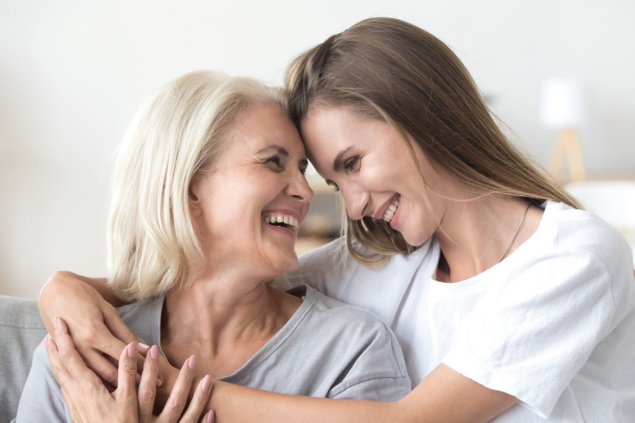 Eine junge Frau umarmt ihre Mutter
