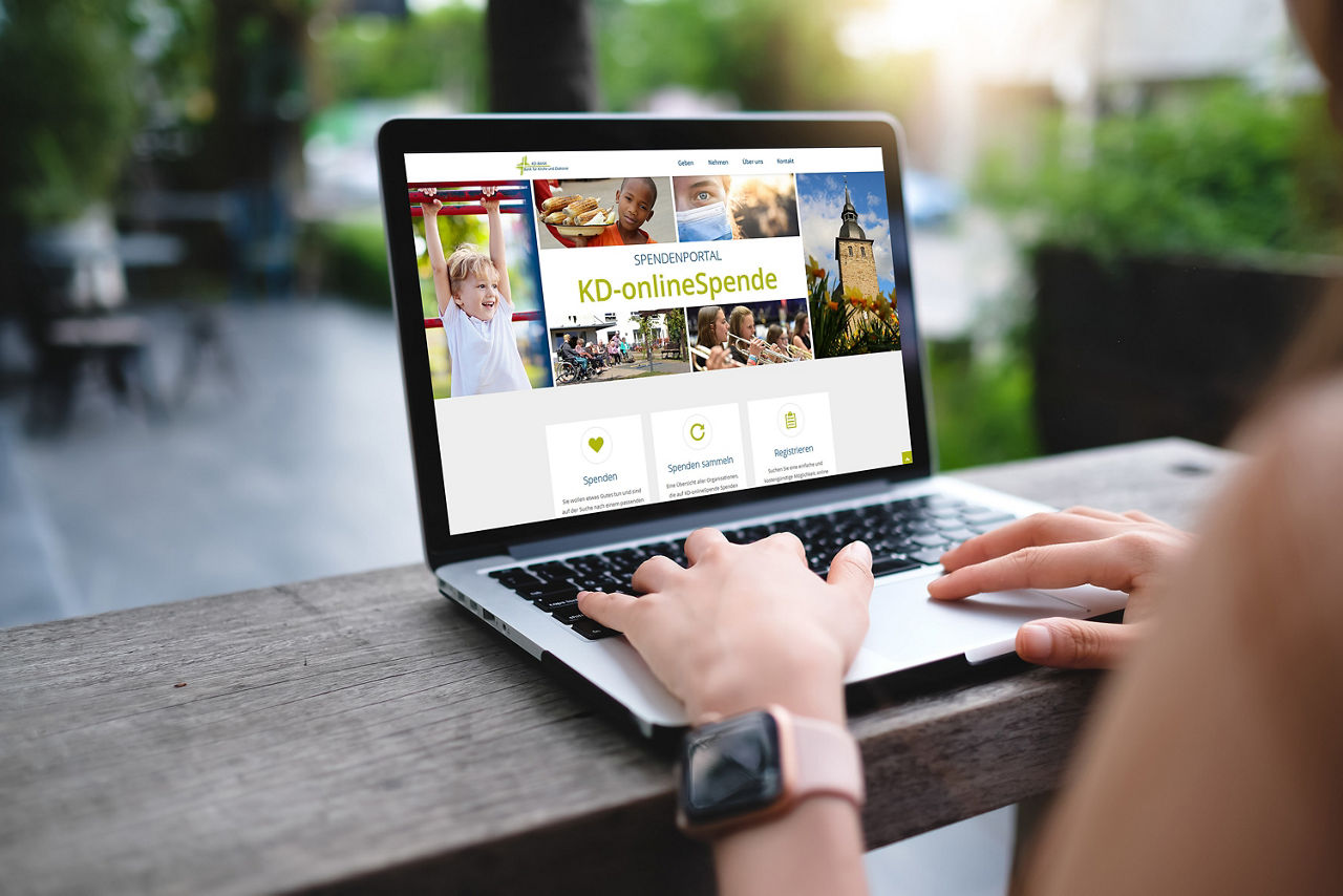 Eine Person arbeitet an einem Notebook, auf dem sie Startseite des Spendenportals geöffnet ist