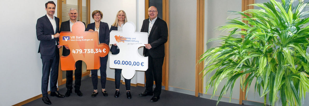 Das Bild zeigt eine symbolische Scheckübergabe, bei der Vertreter der VR Bank eine Spende über 539.738,34 Euro für regionale Projekte präsentieren.