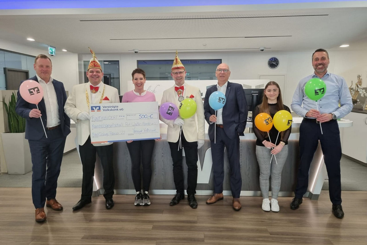 7 verkleidete Personen, die einen Spendenscheck in der Hand halten