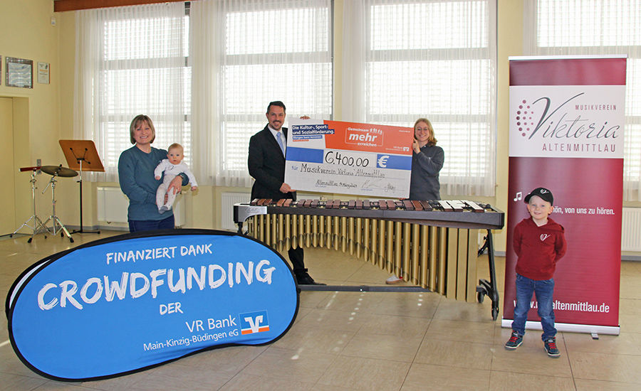 Das Bild zeigt die Spendenübergabe in Höhe von 6.400 Euro an den Musikverein Altenmittlau. Vertreter der VR Bank überreichen einen Scheck zur Unterstützung des Crowdfunding-Projekts.