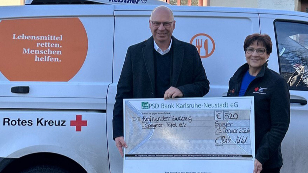 Ein Mitarbeiter der PSD Bank und eine Mitarbeiterin der Tafel Speyer werden mit einem übergroßen Scheck fotografiert.