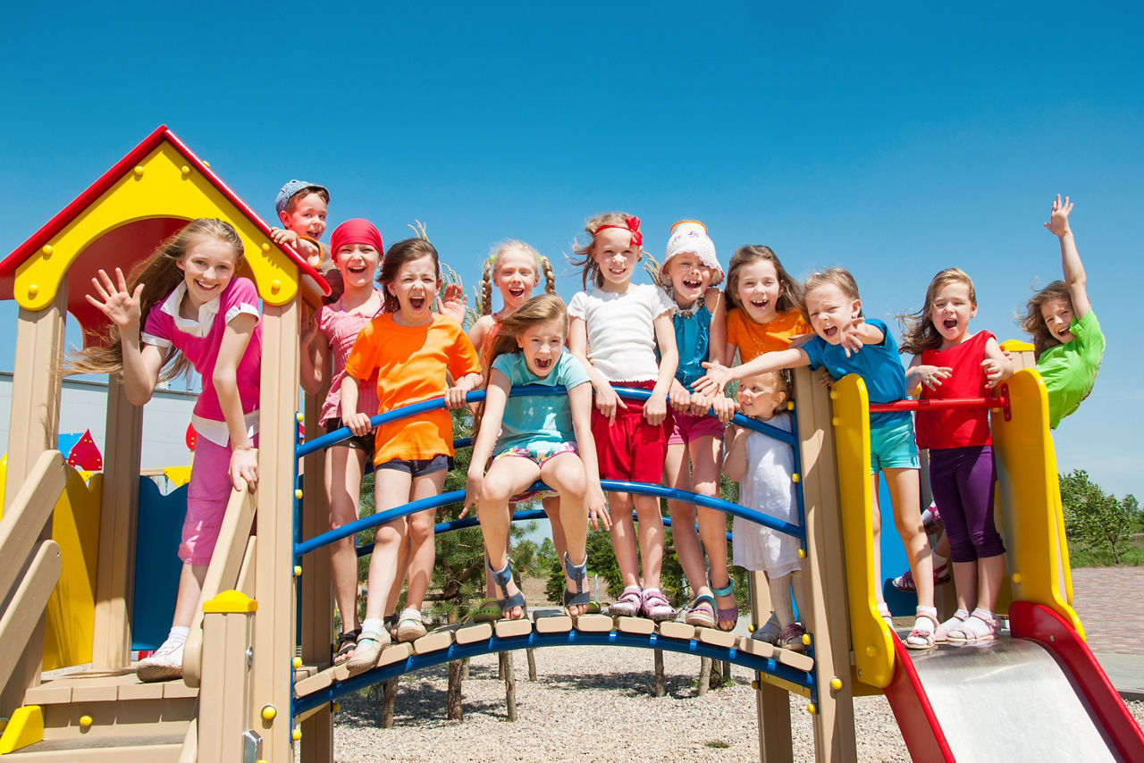 Eine Gruppe von jubelnden Kindern auf einem Klettergerüst