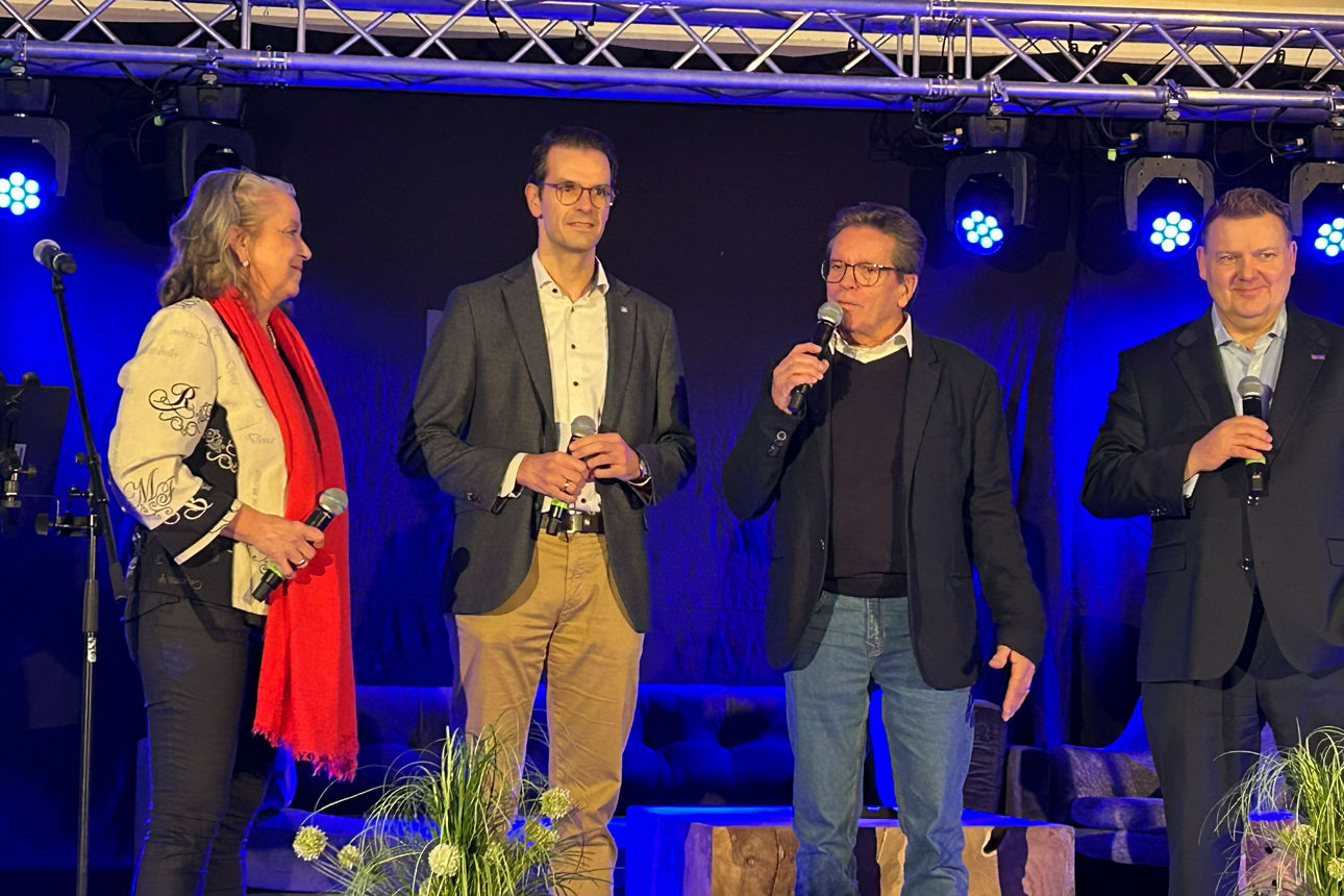 Eine Frau und drei Männer auf einer Bühne