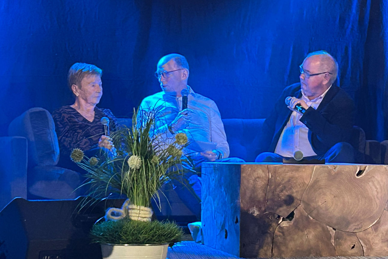 Eine Frau und zwei Männer auf einer Couch